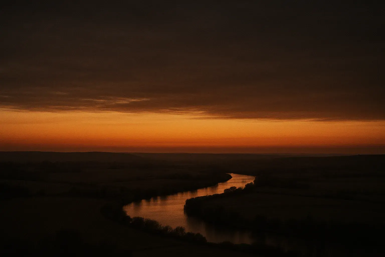 Wide dusk sky over the Seine valley near Herblay-sur-Seine, rendered in warm ink-black and amber duotone, evoking quiet height before a decisive move.